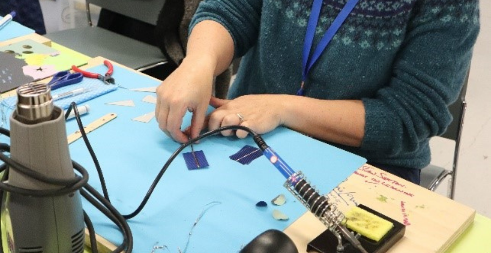 Chloe Uden, founder of Art and Energy, demonstrating how to solder the solar cells (Photo credit: Smart Citizens Programme)