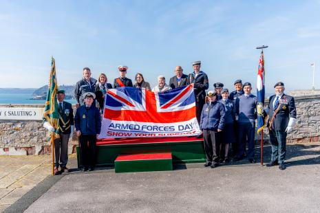 The Armed Forces Day Flag with members of Plymouth City Council, Armed Forces and Babcock behind it